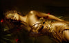 Golden figure reclining on golden silk with roses and a Venetian mask, radiating mystery and divine feminine energy.