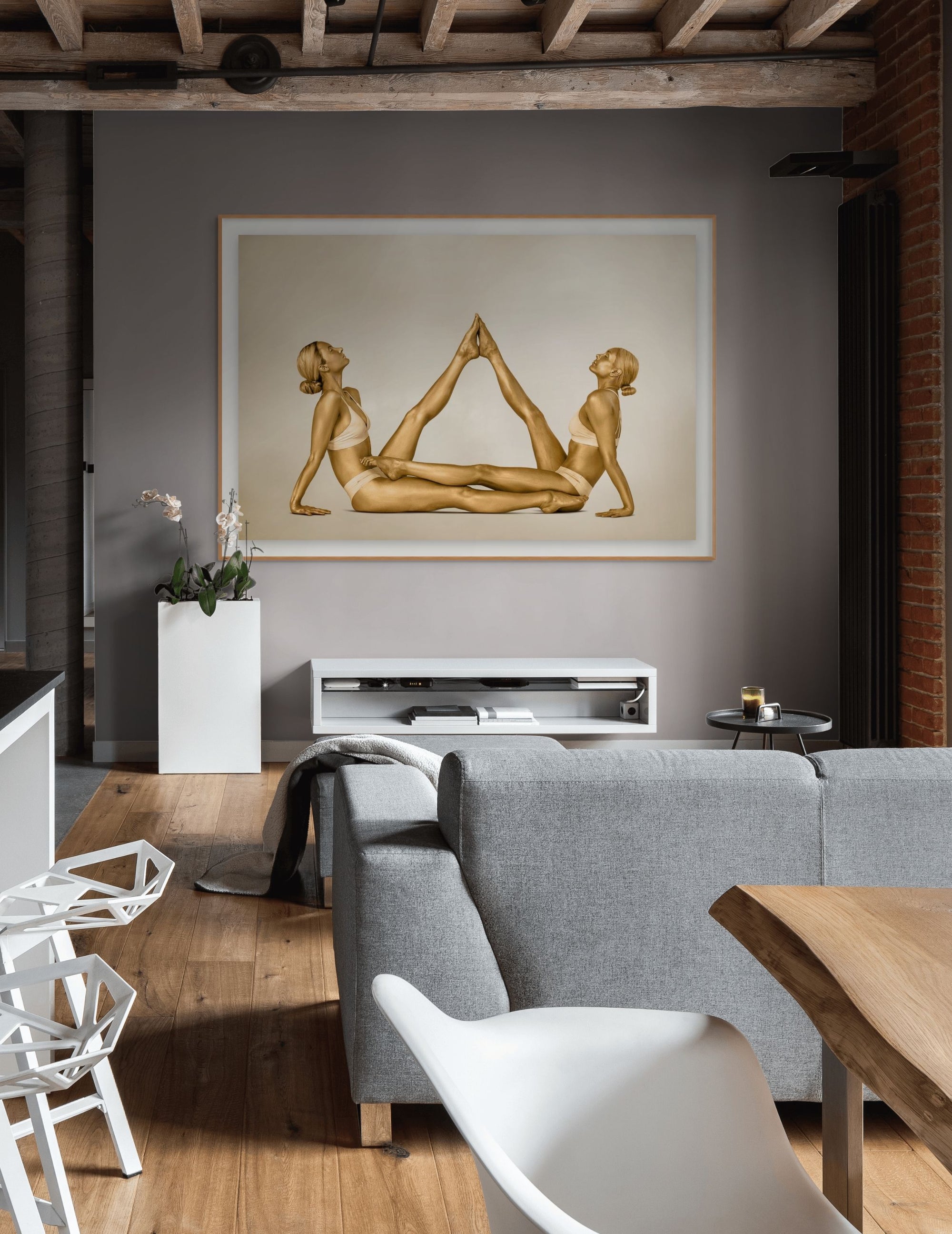 Golden-painted female duo in a synchronized pyramid yoga pose, captured in fine art photography. This elegant contemporary artwork symbolizes balance, unity, and strength, perfect for modern interiors, wellness studios, luxury spas, or art collectors seeking zen wall decor.