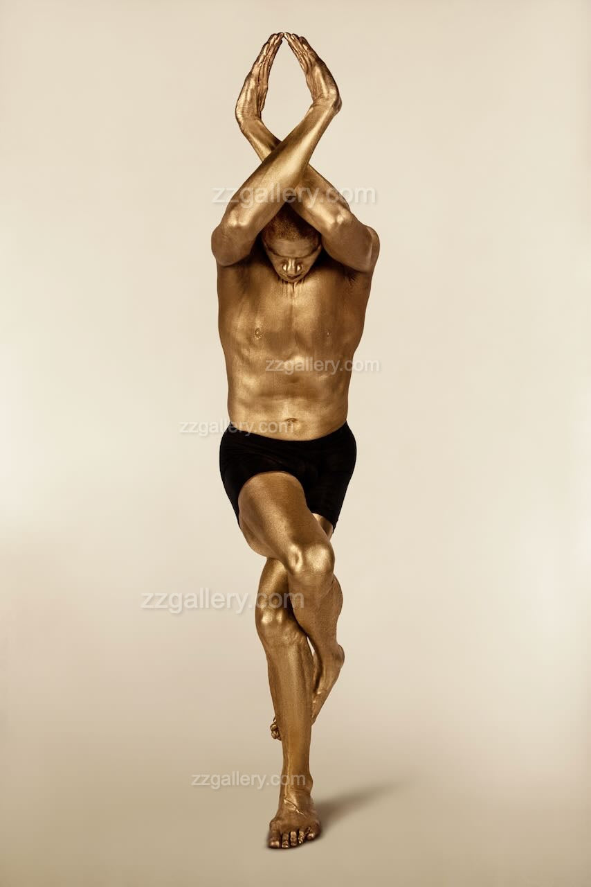 Golden-painted male body in eagle yoga pose with arms crossed above head, luxury fine art wall decor for modern minimalist interiors, wellness studios, and meditation rooms.