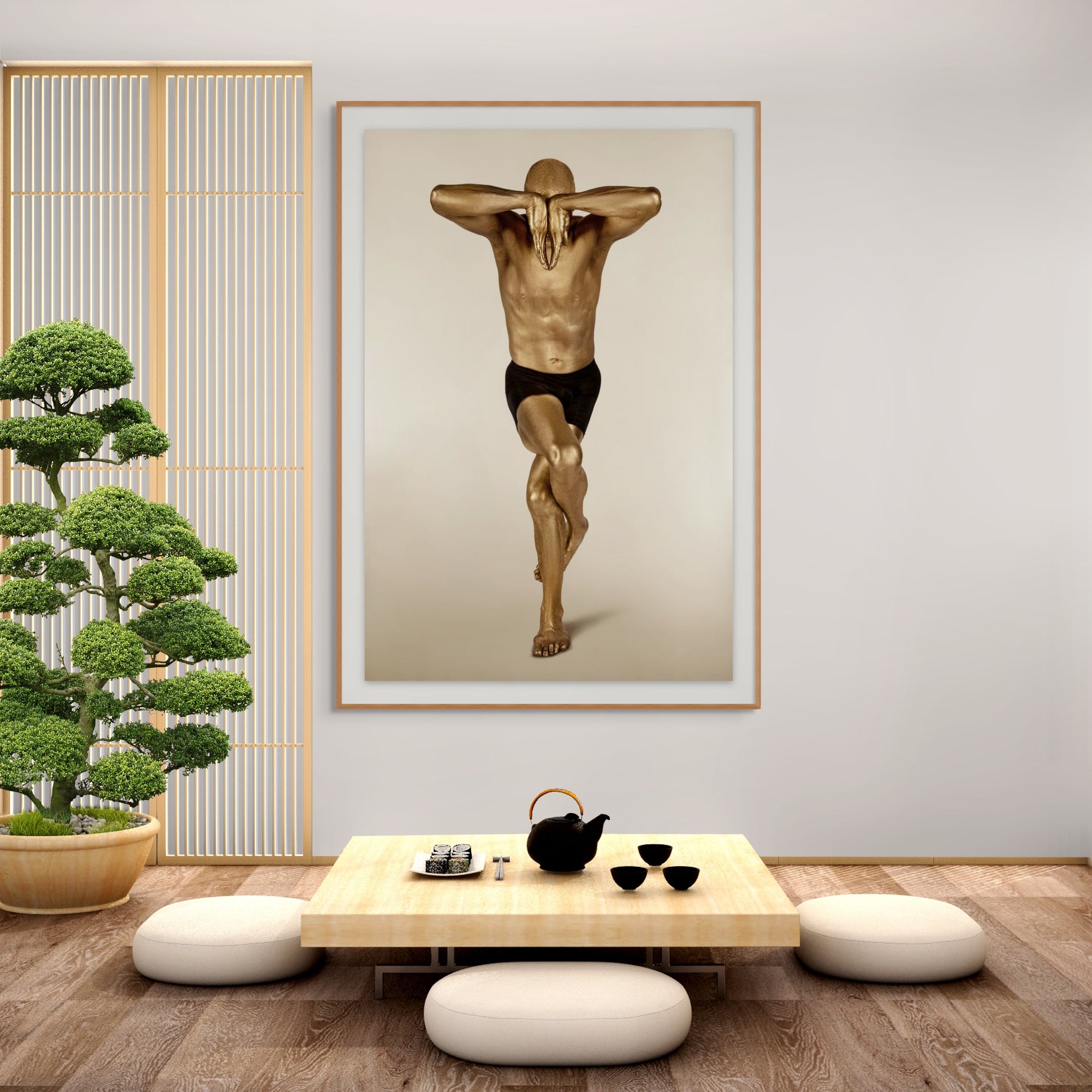 Golden-painted male figure in an elegant yoga balance pose, fine art photography displayed in a Japanese zen-style interior with bonsai and low tea table, perfect for wellness and meditation spaces.