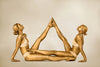 Gold-painted women in mirrored yoga-inspired duo pose, fine art photography print for luxury hotels, spas, wellness retreats, and collectors.