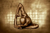 Golden-painted figure in a sculptural side bend with arm extended overhead, captured against a gold-toned background. Fine art photography highlighting strength, balance, and contemporary elegance.