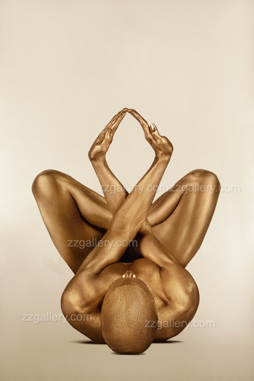 Golden yogi lying on back in triangle pose with hands and feet touching, sacred and geometric.