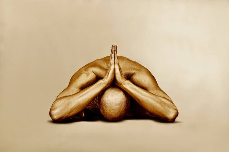 olden-painted figure in a contemplative pose – fine art photography by Zack Zublena, luxury gold silhouette wall decor for interiors and wellness spaces.