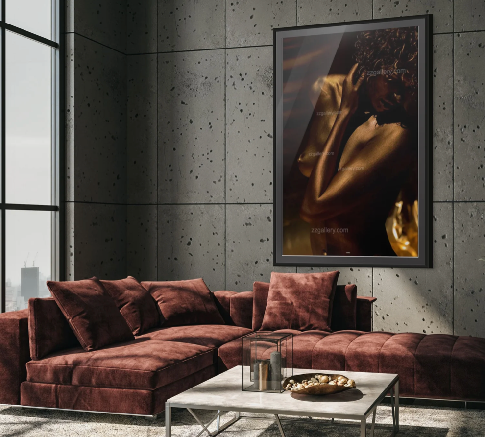 Modern living room with a burgundy velvet sectional sofa, concrete panel walls, large framed artwork, coffee table with candles and bowl, and a potted plant near floor-to-ceiling windows.