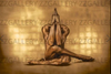 Golden-painted male nude seated in prayer with deep dark background – The Pilgrim devotional fine art photography by Zack Zublena.