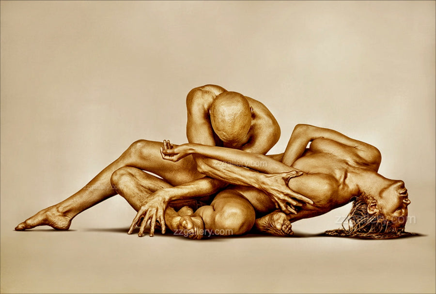 Golden-painted nude couple in a sacred surrender pose, fine art wall photography displayed in a luxury modern living room above a fireplace — elegant gold body art decor for spas, wellness retreats, and sophisticated interiors.