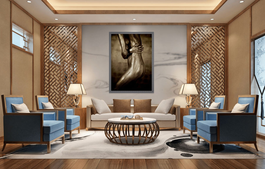 Golden-painted silhouette fine art photography by Zack Zublena, feminine figure shielding her torso, displayed as elegant wall art in a modern living room.