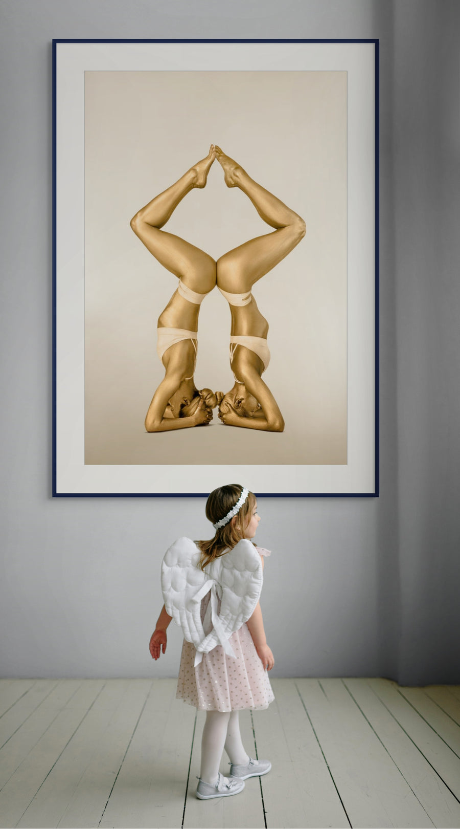 Golden-painted female duo in synchronized headstand yoga pose forming a perfect diamond shape with their bodies, captured in fine art photography. Symbolizes balance.