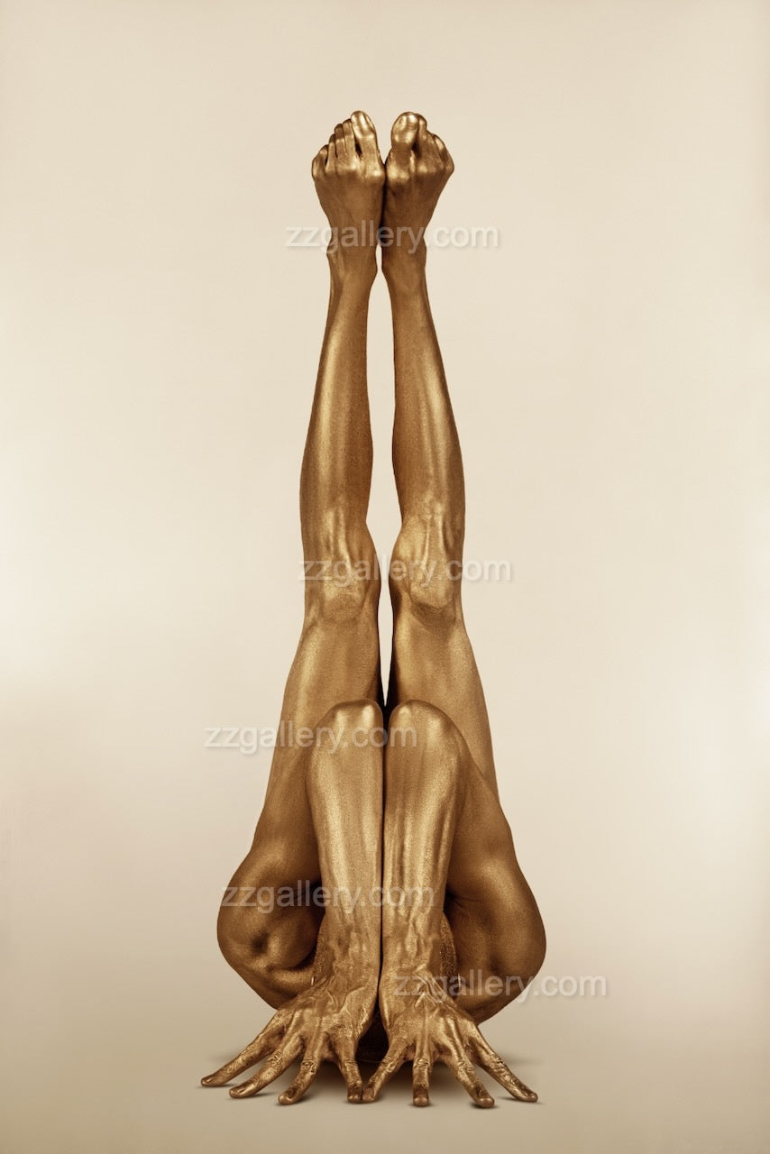 Golden yoga figure in an iconic vertical pose with sculptural legs extended upward, highlighting symmetry, strength, and balance.