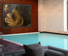 Golden Souls fine art photography print by Zack Zublena displayed in a luxury poolside interior, featuring a woman in shimmering gold tones draped in translucent fabric.
