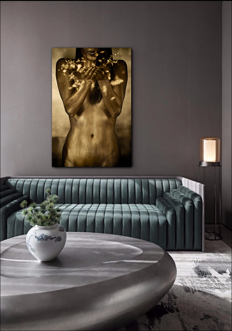 Golden-painted figure releasing radiant particles of light from her hands, contemporary fine art wall piece for luxury interiors and spas.