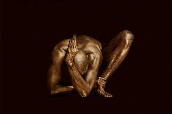 Golden-painted male figure in a sculptural yoga-like pose against a dark background, fine art photography highlighting strength, balance, and elegance. Luxury wall art for interiors, spas, and collectors.