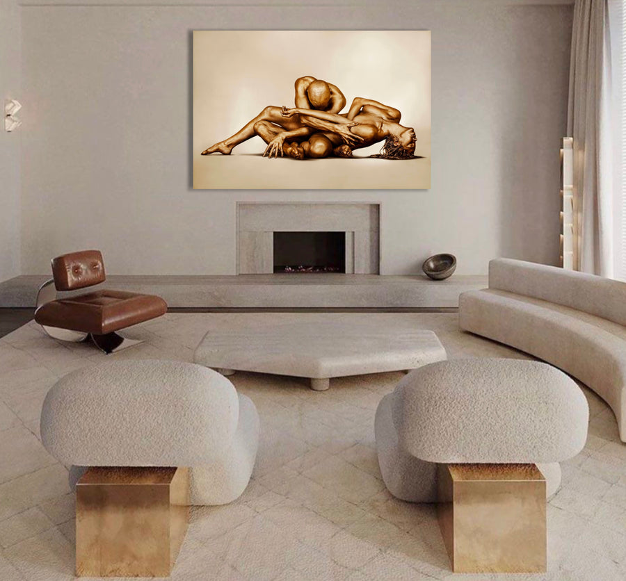 Golden-painted nude couple in a sacred surrender pose, fine art wall photography displayed in a luxury modern living room above a fireplace — elegant gold body art decor for spas, wellness retreats, and sophisticated interiors.