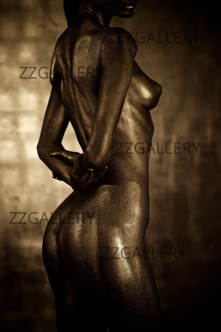 Golden-painted figure in sculptural back pose, contemporary fine art photography highlighting form, light, and artistic elegance.